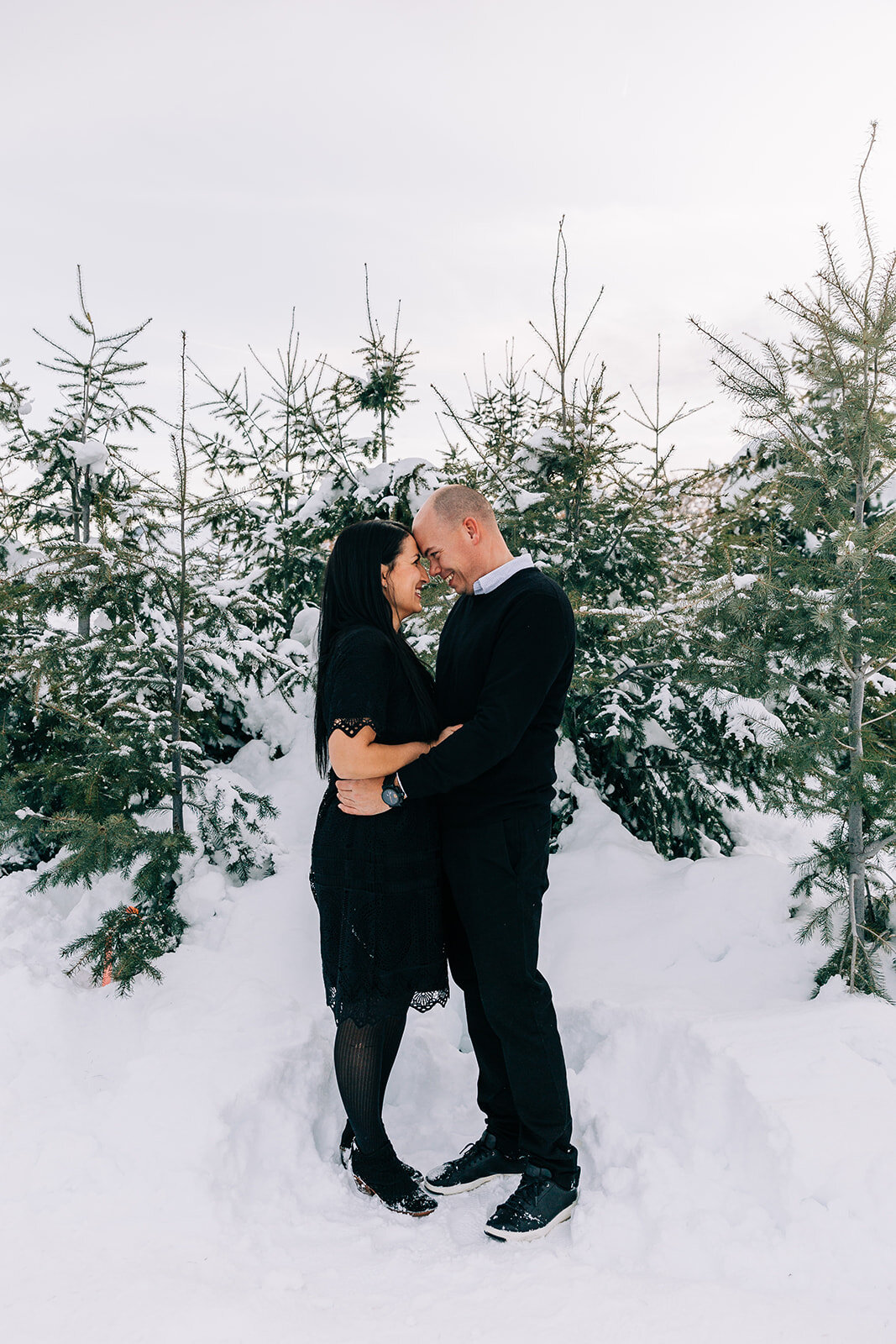  man and wife hugging intimate pose inspo winter fashion family pictures daughters family picture styling inspiration family pose ideas winter photoshoot snowy pictures adams acres tree farm family photographers in utah professional family photograph