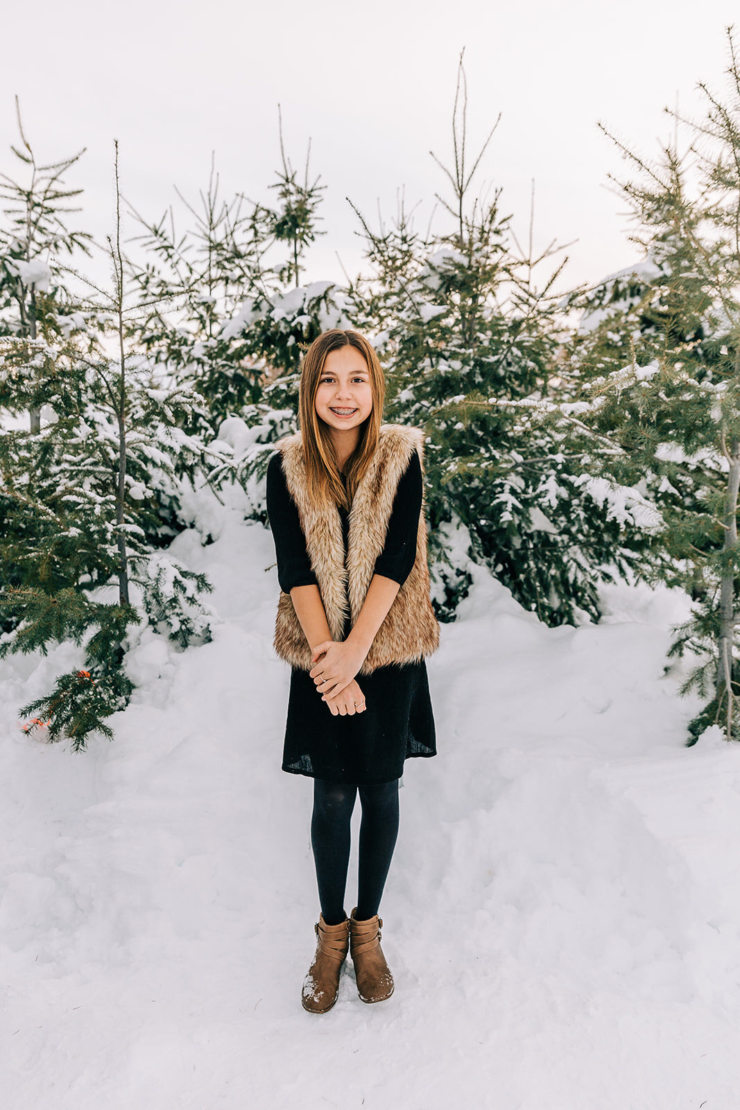  preteen faux fur vest styling braces winter fashion family pictures daughters kid fashion family picture styling inspiration family pose ideas winter photoshoot snowy pictures adams acres tree farm family photographers in utah professional family ph