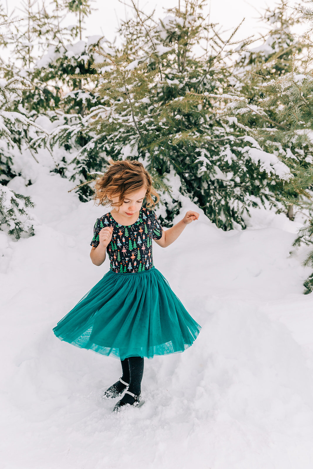  young girl twirling in a tulle dress fun pose ideas winter fashion family pictures daughters family picture styling inspiration family pose ideas winter photoshoot snowy pictures adams acres tree farm family photographers in utah professional family