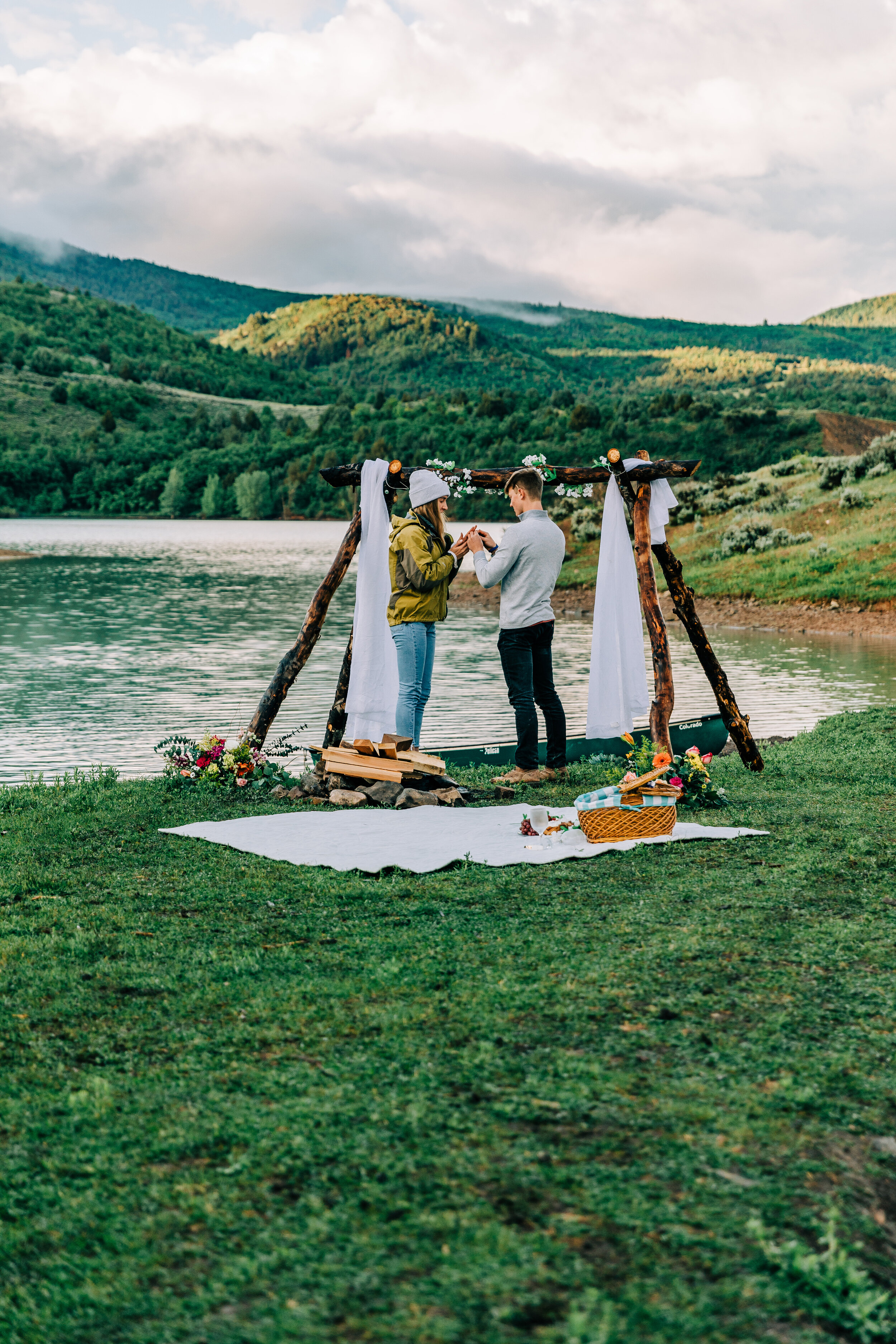  A unique sunrise picnic proposal on the shore of Porcupine Dam. Bella Alder Photography professional Utah photographer surprise proposal engagement session inspiration trying on the ring for the first time couple goals proposal goals beautiful boho 