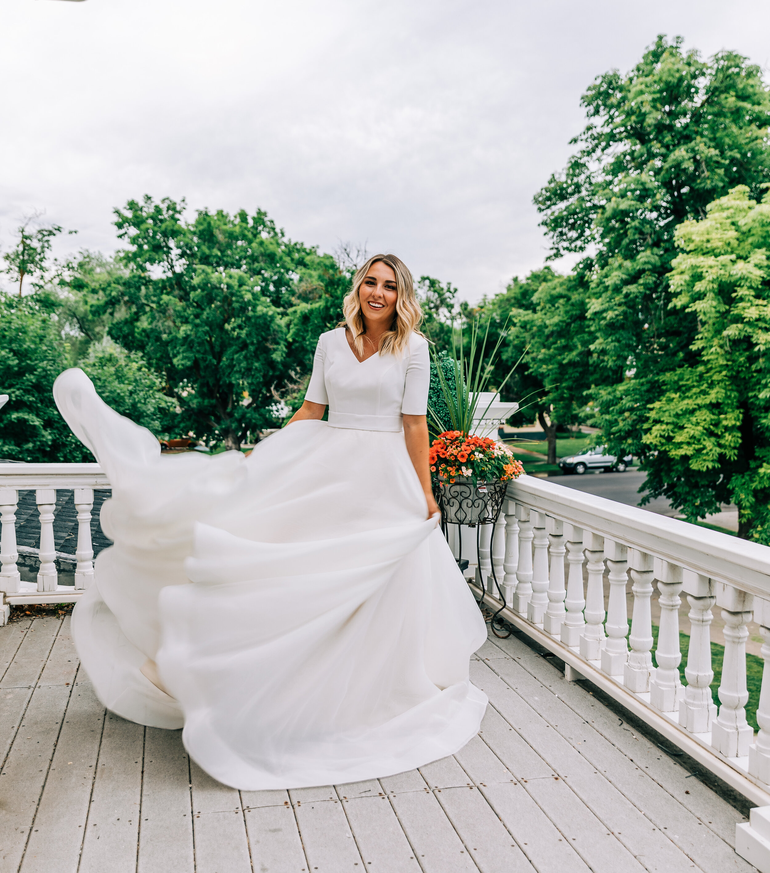  A glowing bride dancing gracefully in her flowing modern ball gown by Elizabeth Cooper Design. Bridal photo shoot inspiration bridal aesthetic Logan photo shoot inspiration Victorian home Utah bridal inspiration bridal pose inspiration modest weddin