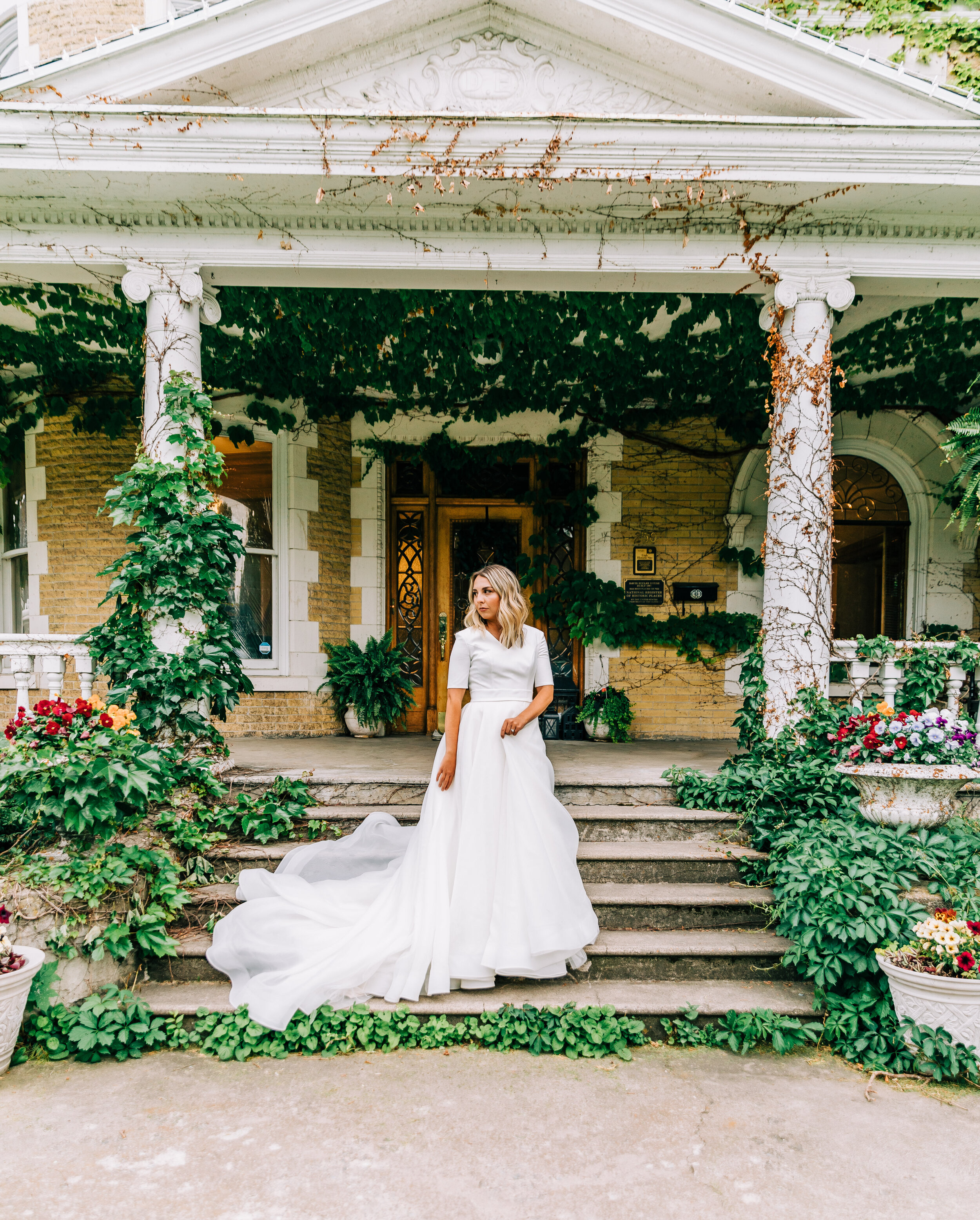  A gorgeous bride standing on the steps of a beautiful Victorian home in an Elizabeth Cooper Design ball gown wedding dress. Bella Alder Photography professional wedding and commercial photographer Utah brides bridal aesthetic wedding inspiration wed