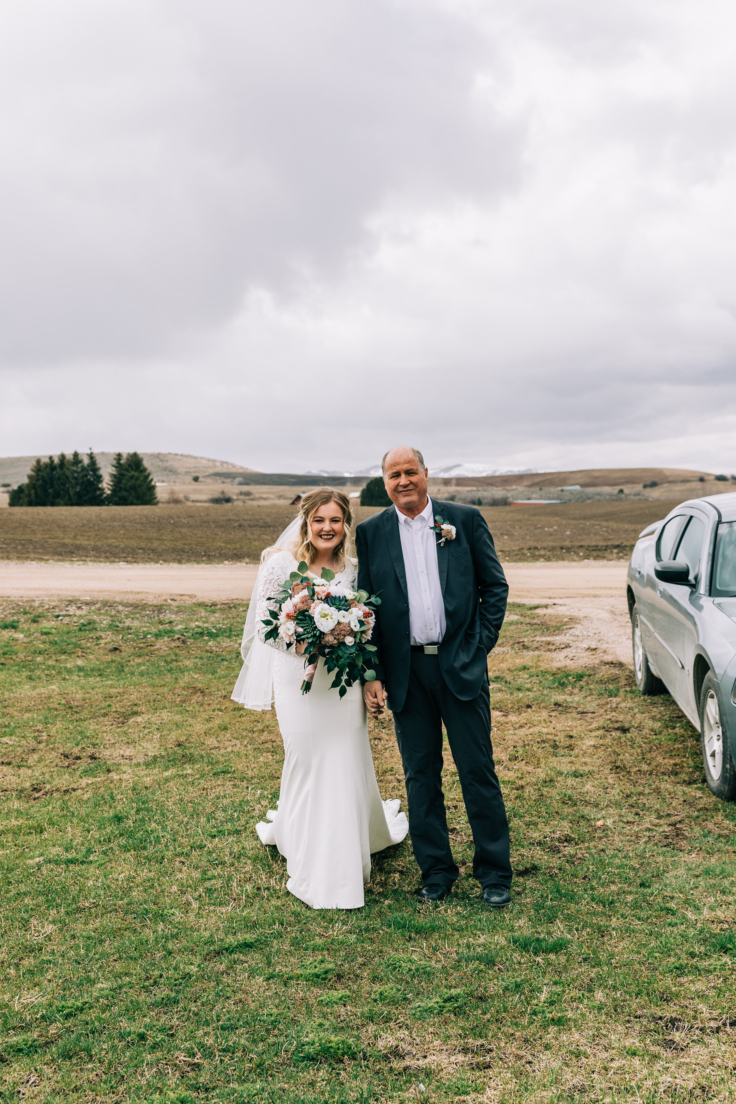  A beautiful bride walking with her father in a stormy elopement styled wedding photo shoot in Preston, Idaho. Elopement wedding inspiration bridal aesthetic stormy weather wedding photo shoot bridal attire inspiration wedding goals bridal goals fath