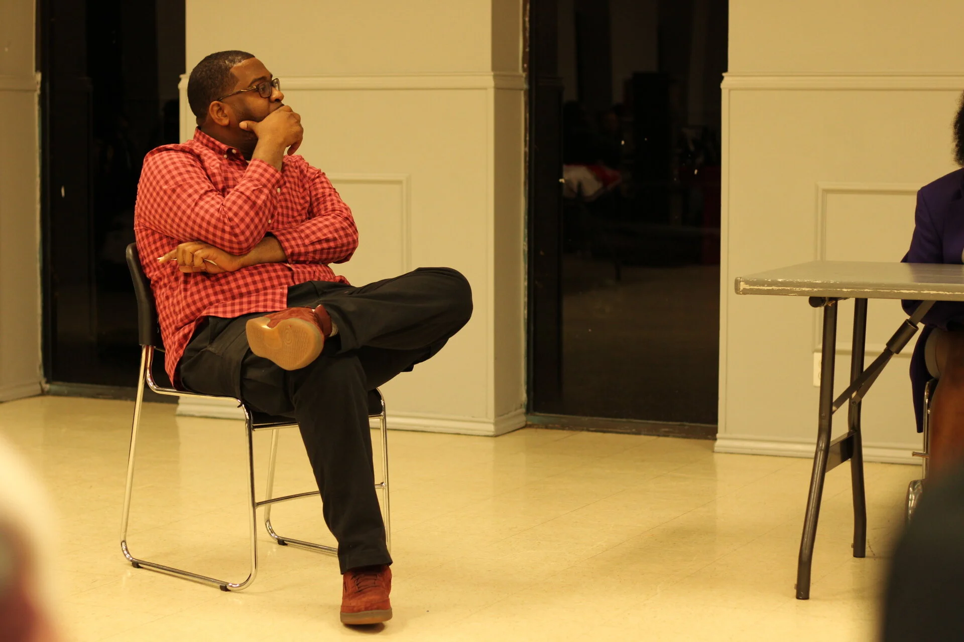 Mr. White the curator &amp; moderator of the event listening to a panelist discuss their experience in business.