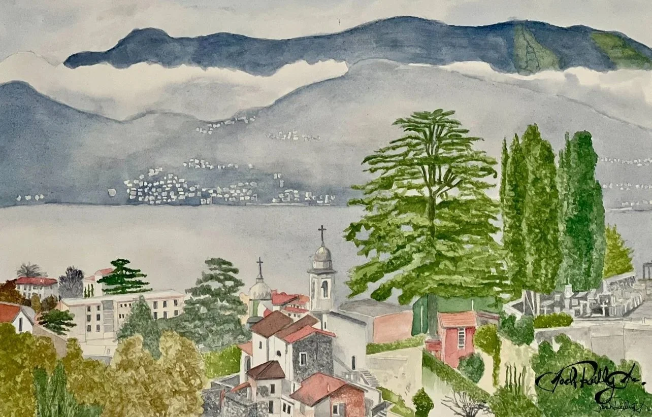 Watercolor painting of a lakeside town with church steeples, lush green trees, and mountains in the background.