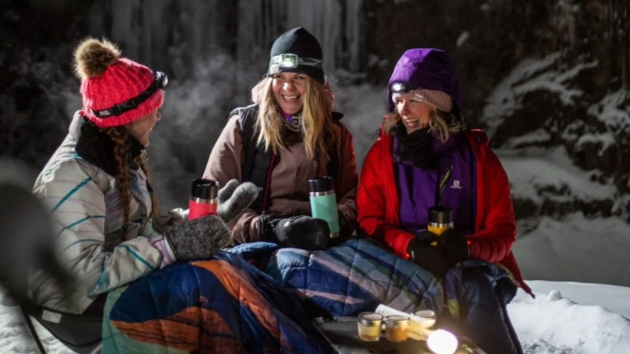 Guided night hike through Grotto Canyon with illuminated ice walls and snow-covered trail near Canmore National Park