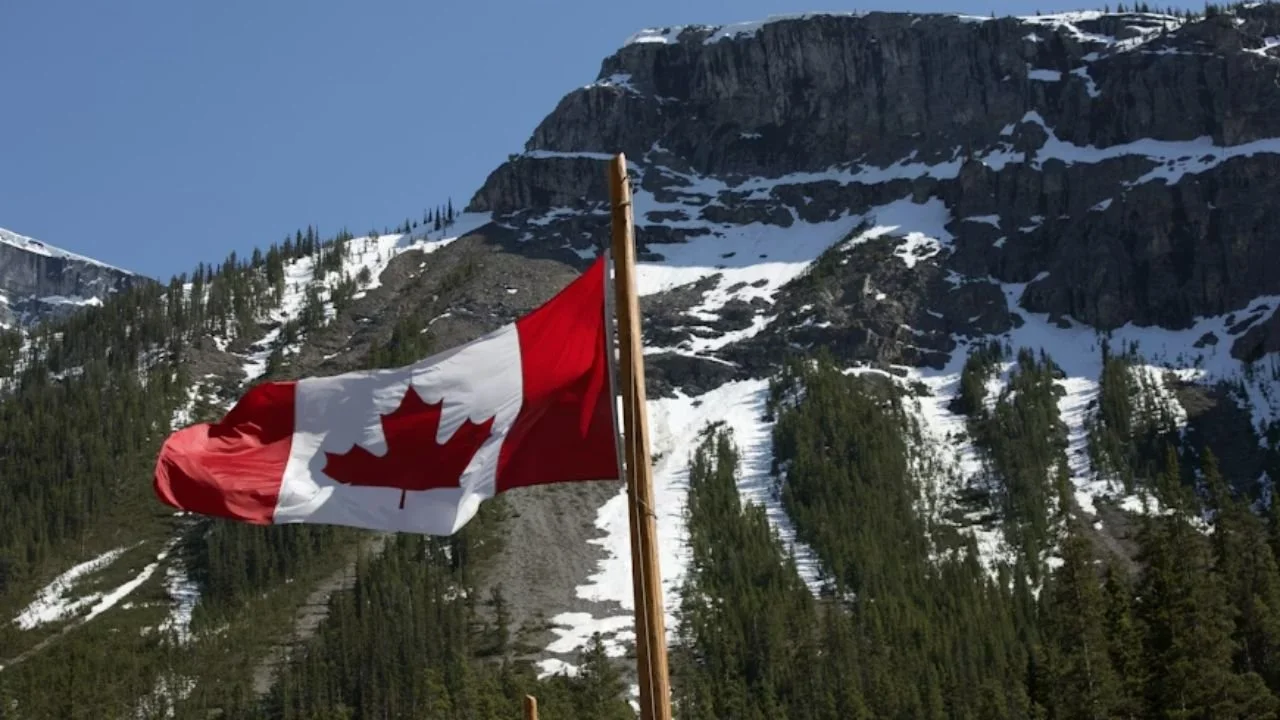 Mountain landscape in the Canadian Rockies with a Canadian flag