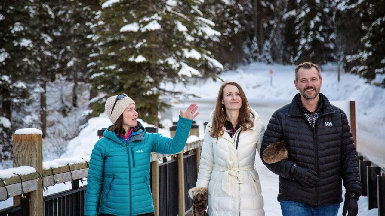 Couple enjoying Lake Louise winter sightseeing with snow-covered mountains 