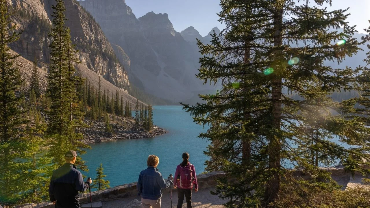 Wide view of Lake Louise with clear water and surrounded by mountains.