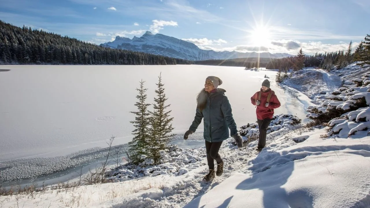 Banff in March, winter hiking trail beside a frozen lake in Banff National Park