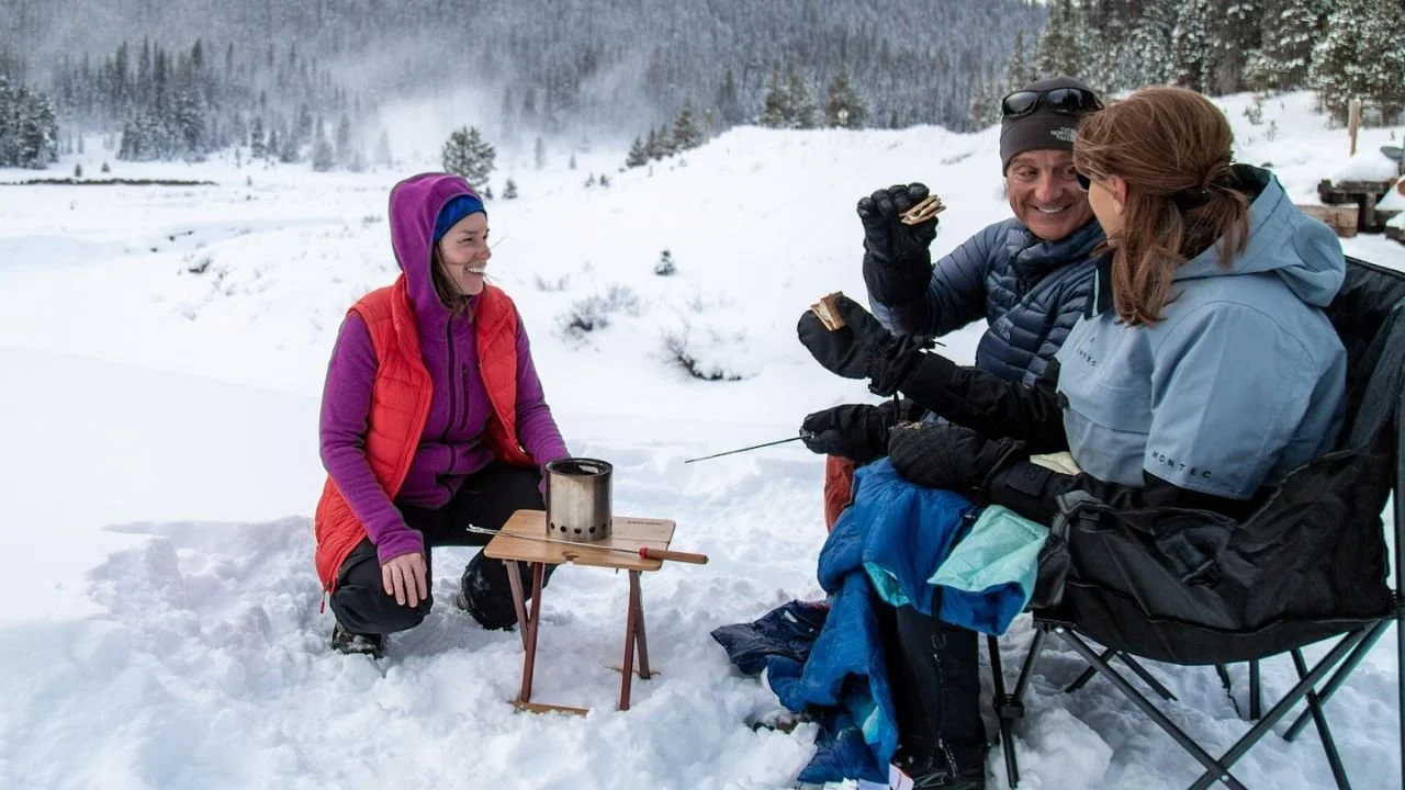 Friends enjoying making s’mores in the snow, showcasing the best things to do in Kananaskis for outdoor adventure lovers.