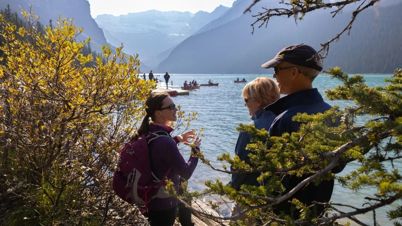 Tour guide explaining Lake Louise scenery to visitors.