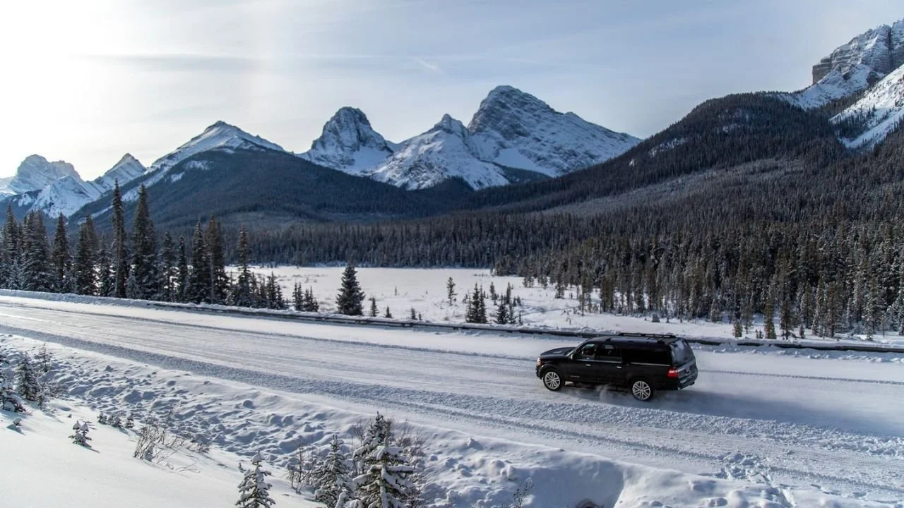 Winter drive past Hogarth Lakes in Canmore with snow-covered mountains and forest scenery.