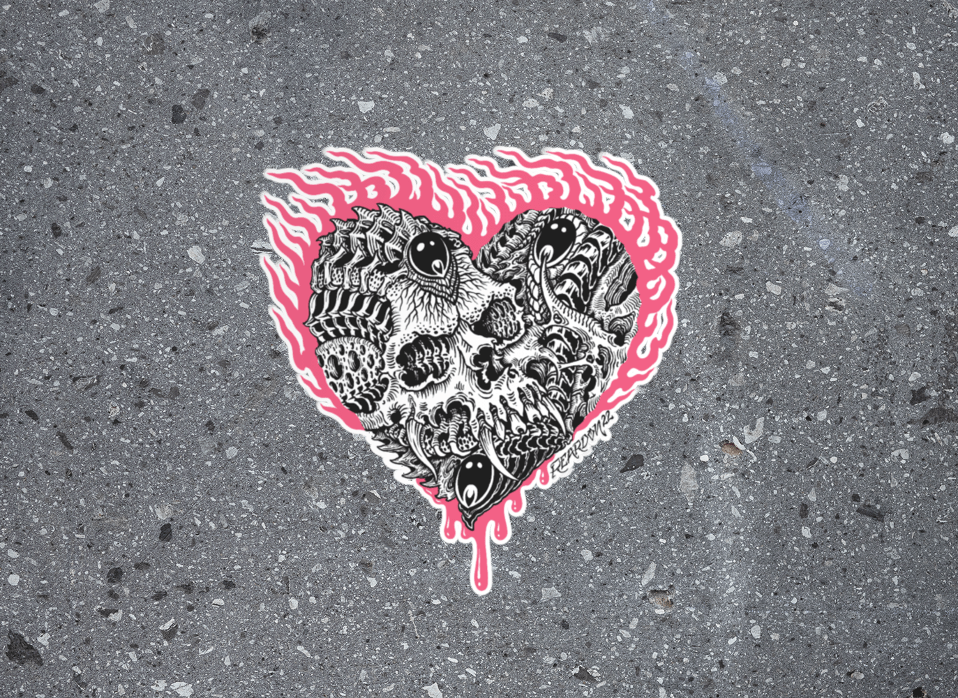 Pink and black skull and flame sticker flat on a concrete background