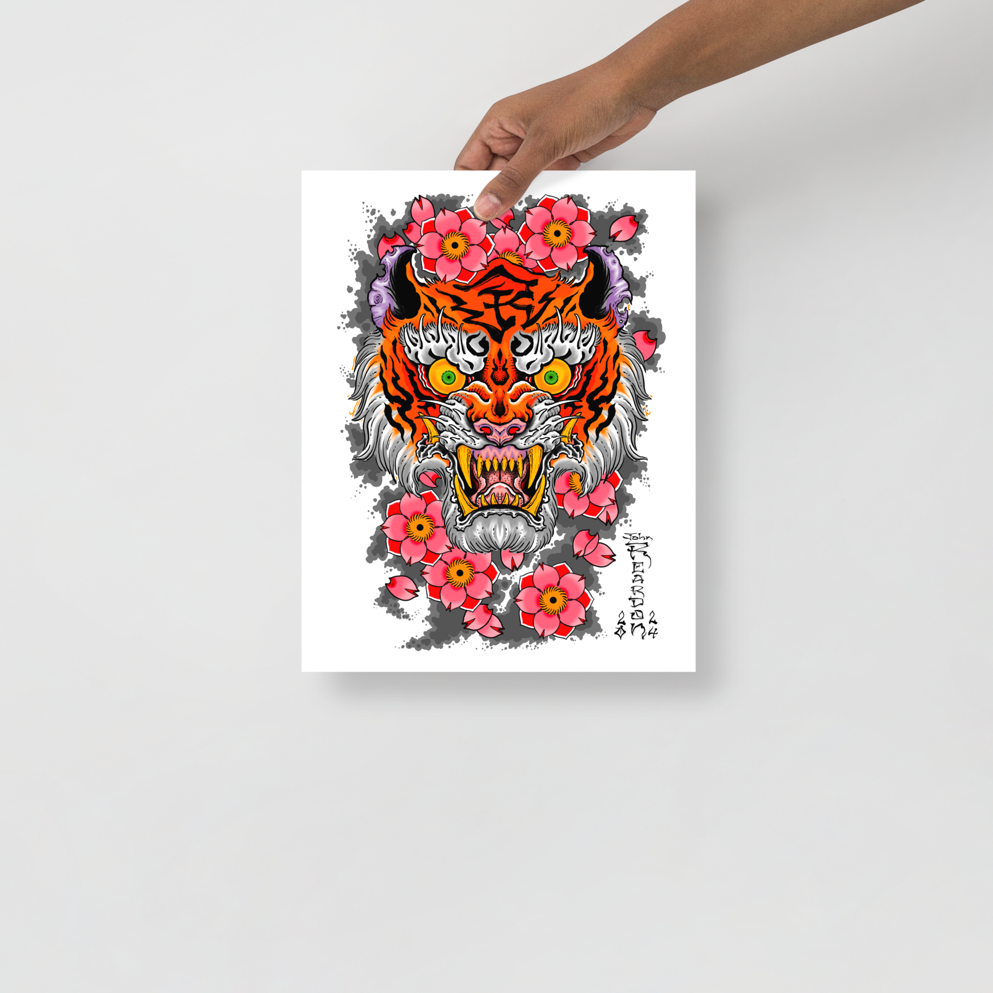 Medium art print of tiger and flowers on white background being held in front of grey tattoo shop wall