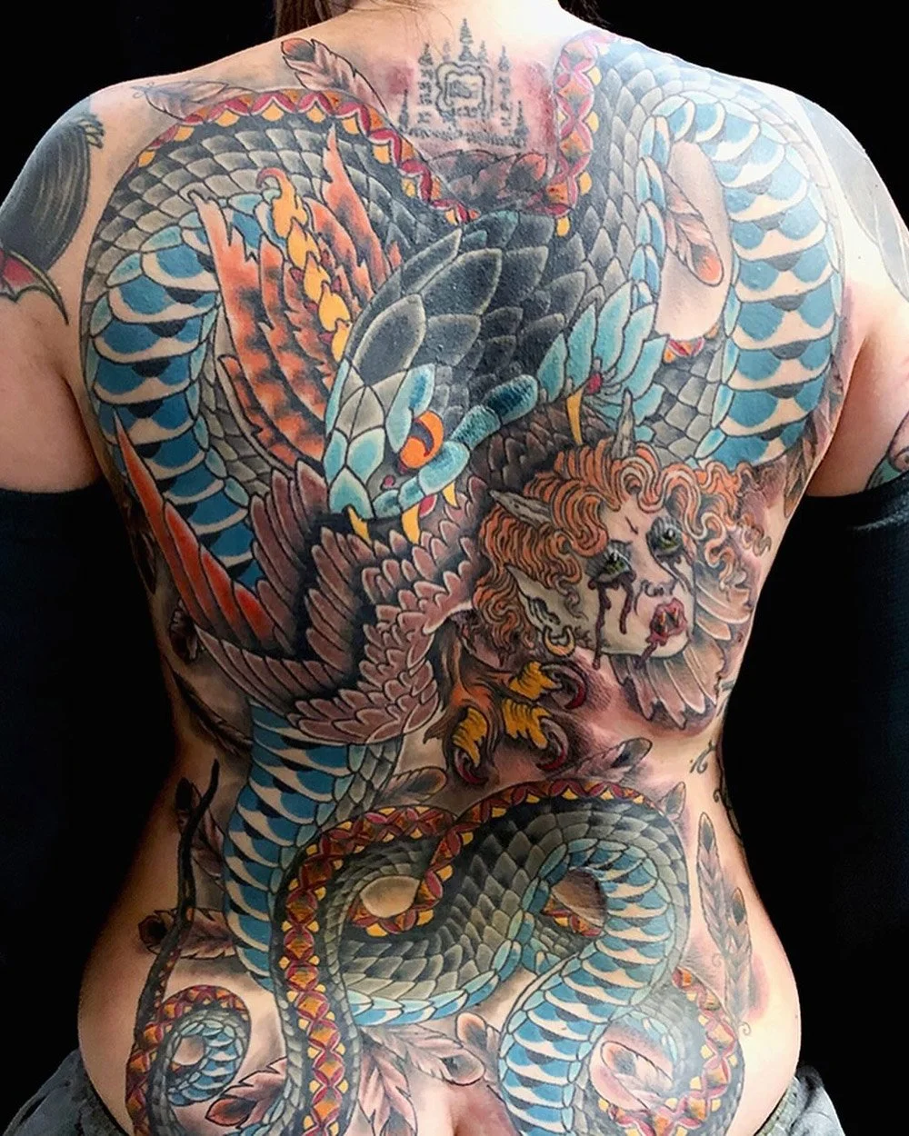 Full backpiece tattoo of a creature n color.