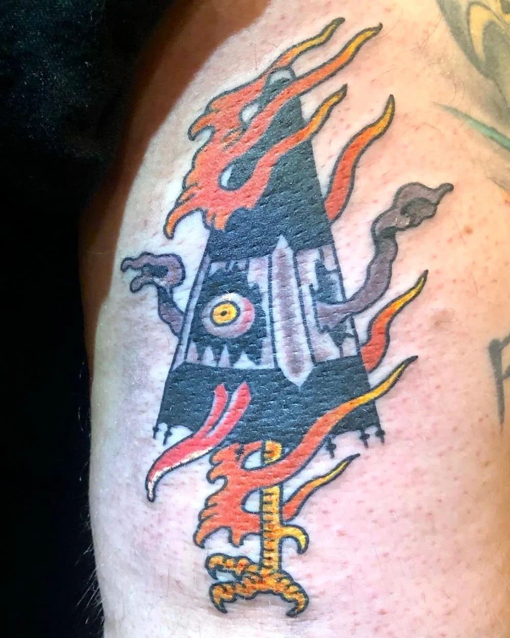 Japanese umbrella demon tattooed in color on an arm.