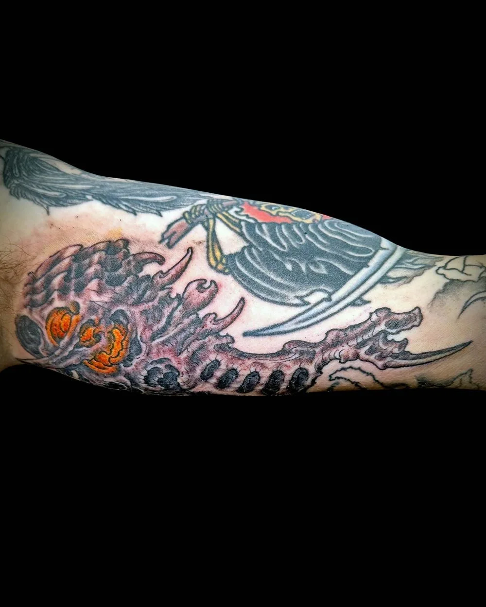 Under and inner arm tattoo in color of a biomech monster by John Reardon.
