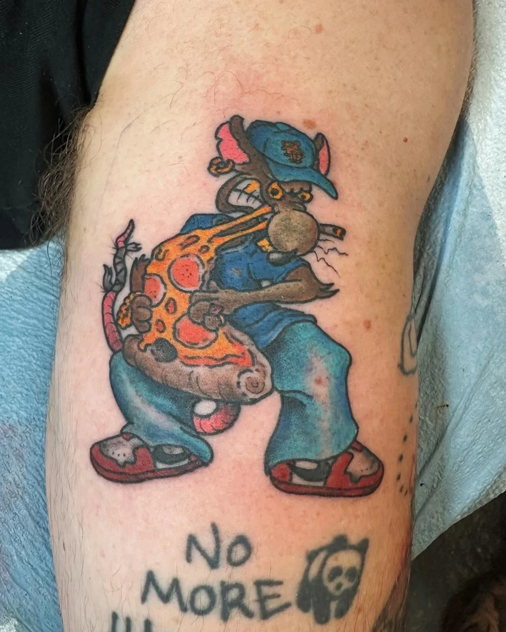 NYC rat eating a slice of pizza tattooed in color in NYC.