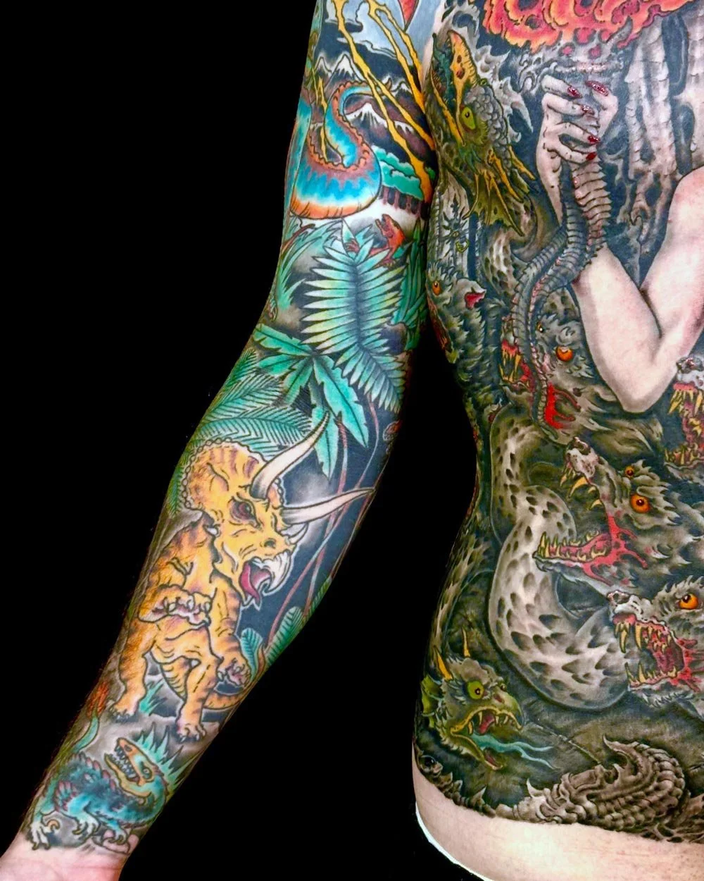 Close-up on the lower arm of a client with color dinosaurs and foliage.