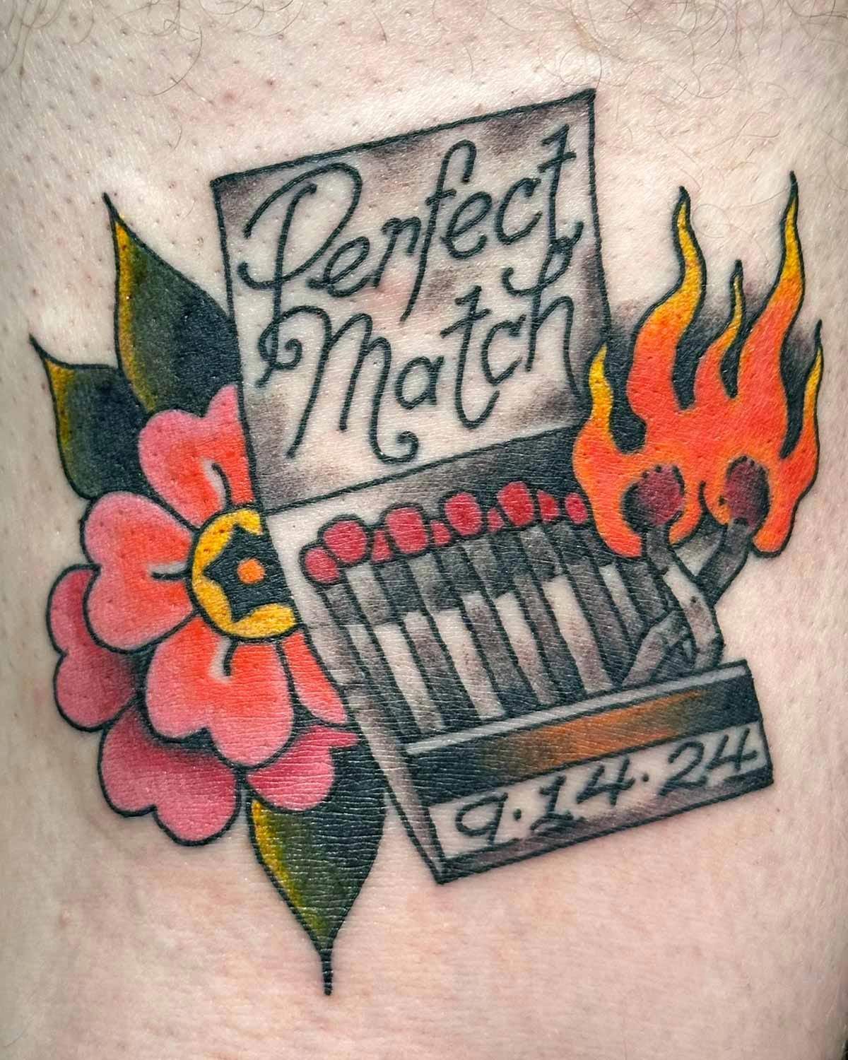 Matchbook tattoo with matches on fire and a flower in the back.