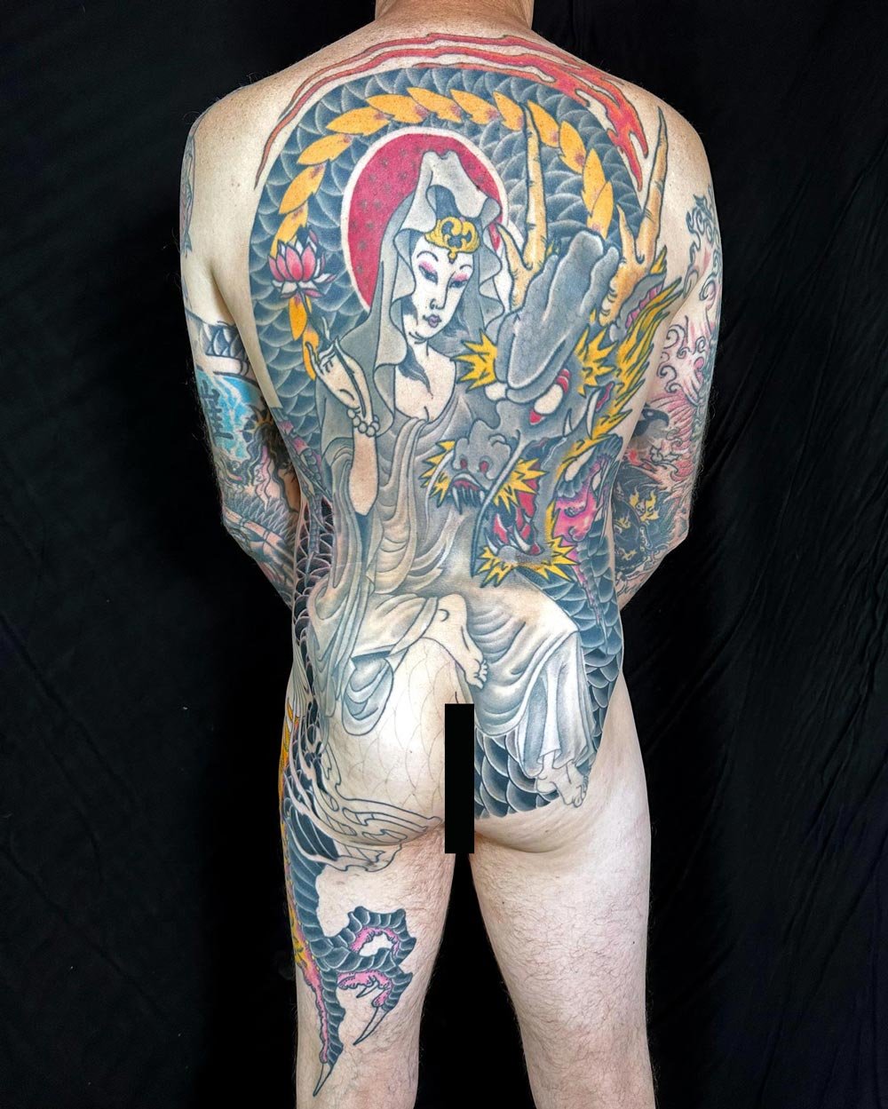 Full backpiece tattoo i n color by John Reardon of a deity riding a dragon.