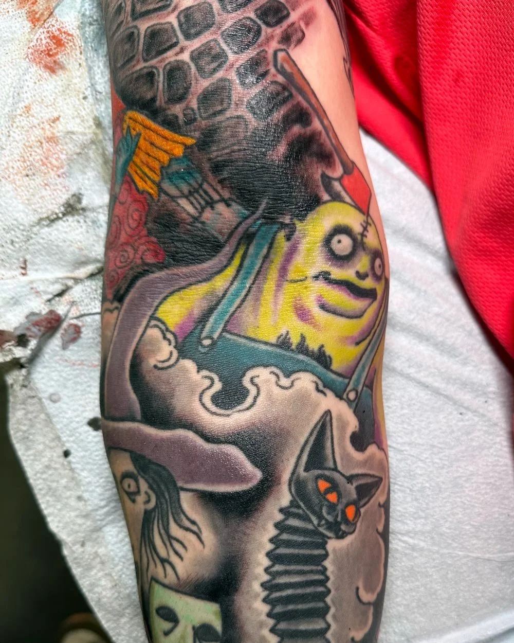 Color tattoo by John Reardon in NYC of Nightmare Before Christmas and other Tim Burton characters.