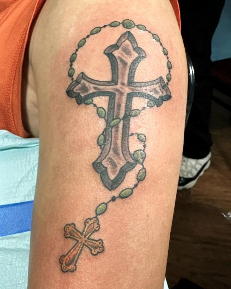 Rosary tattoo in color on shoulder and upper arm.
