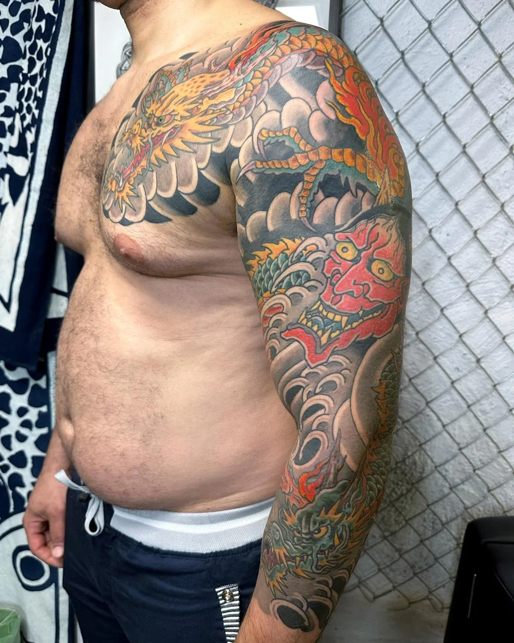 Side view of a John Reardon full tattoo sleeve in color.