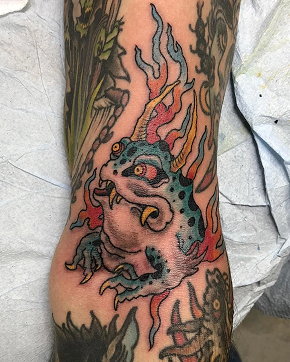 Japanese color tattoo of a frog and lightening on a leg.