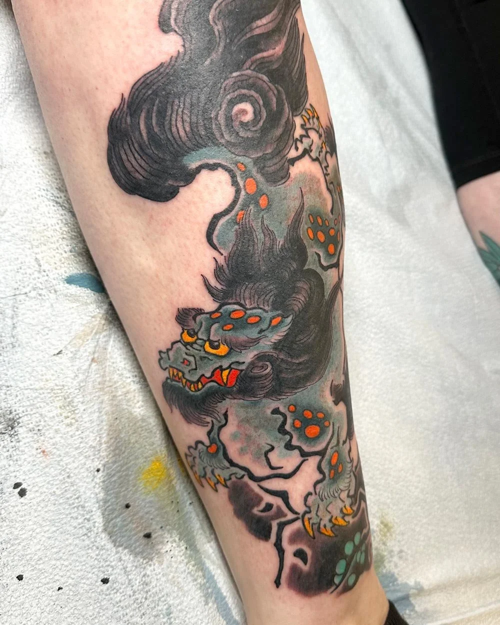 Color tattoo of a Japanese Foo dog on a calf.