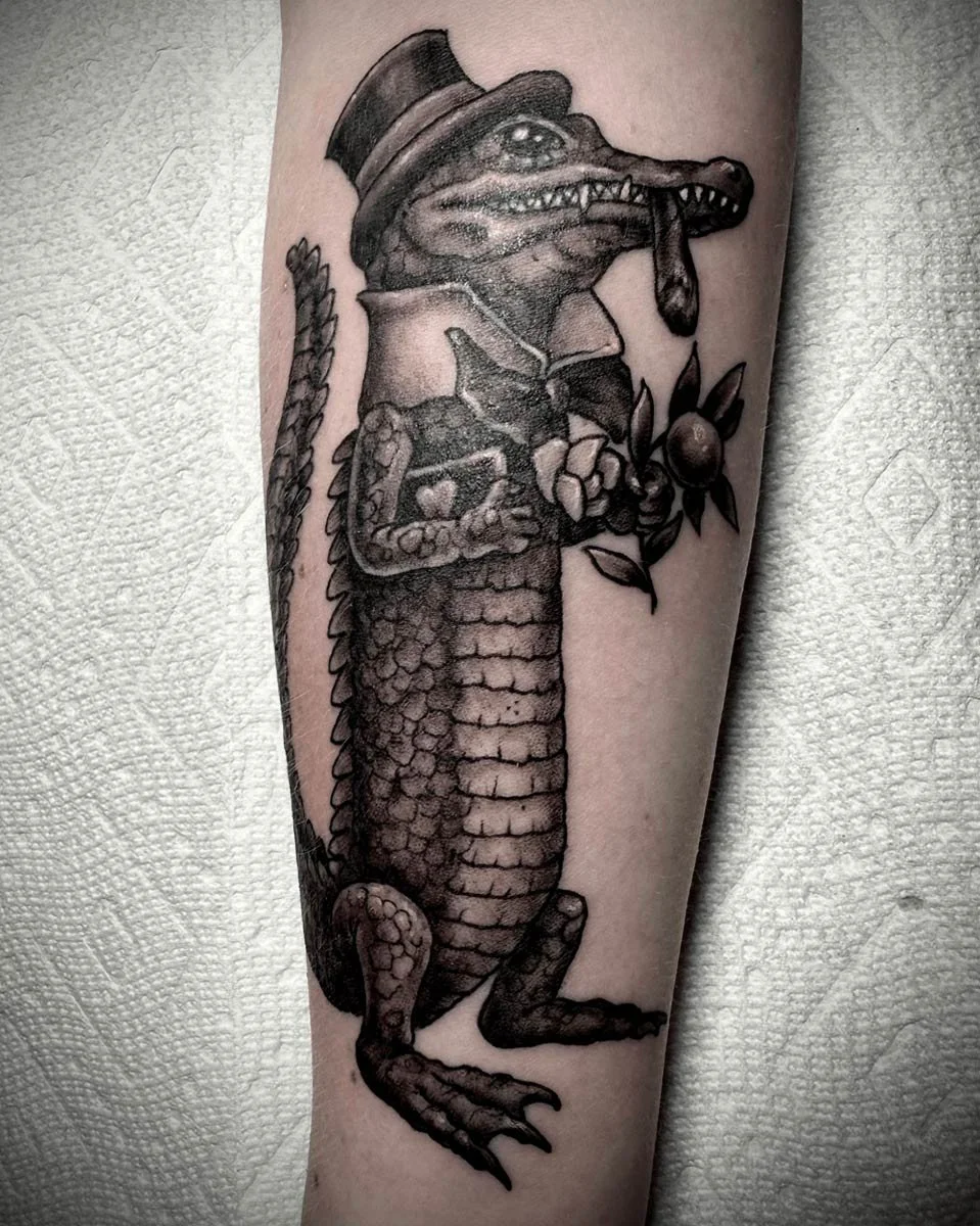 Aligator in a top hat, smoking a cigar and holding flowers.