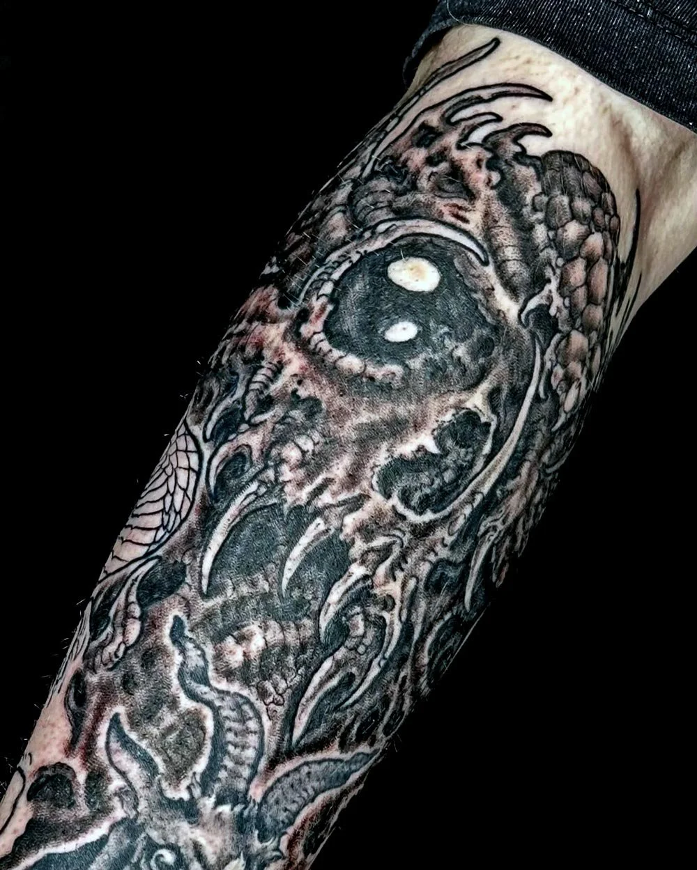Biomechanical black and grey tattoo on upper arm of a skull by John Reardon.