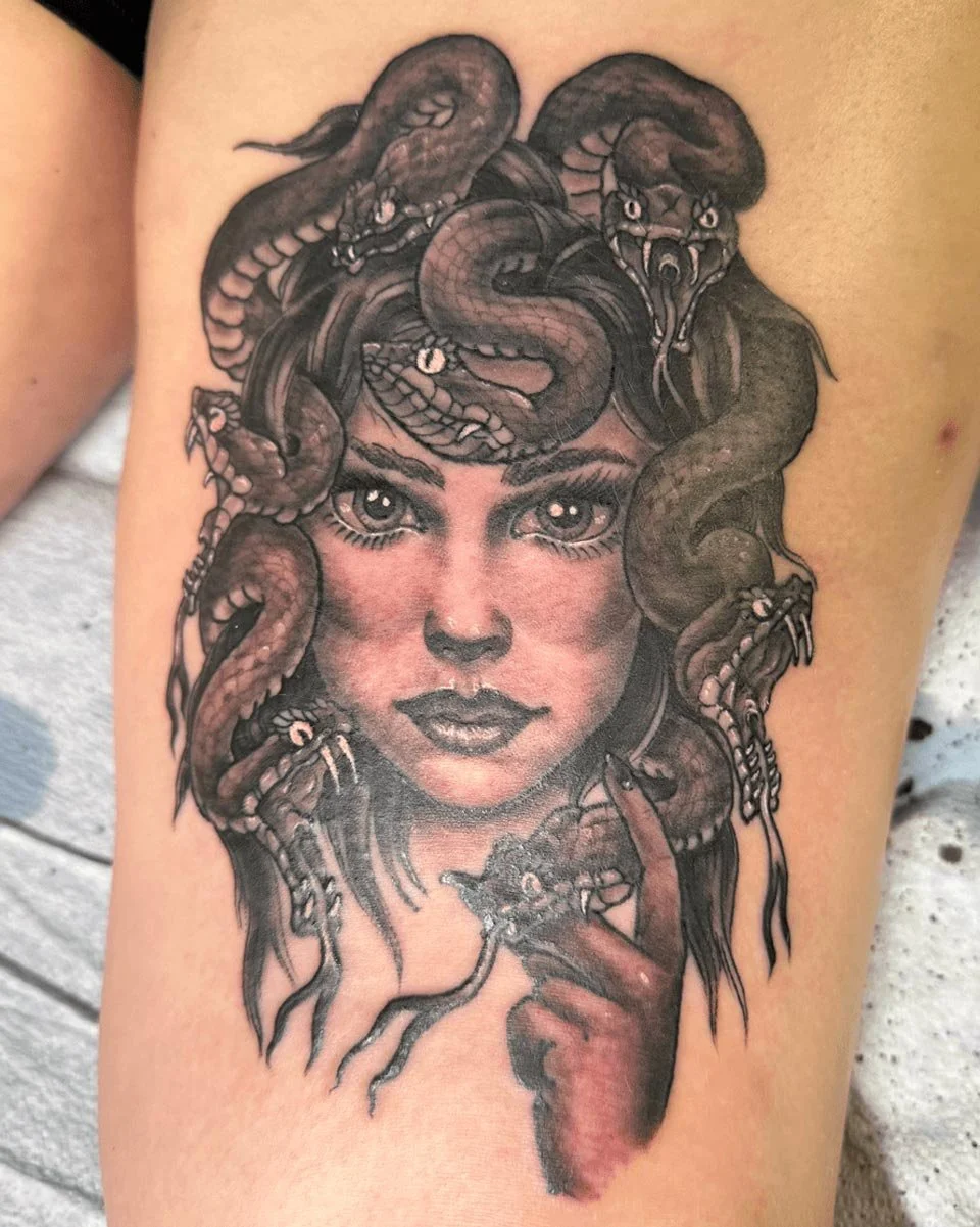 Black and grey tattoo portrait of medusa with snakes in her hair.