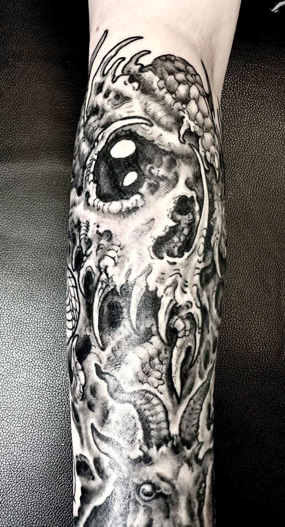 Biomech skull tattoo in black and grey.
