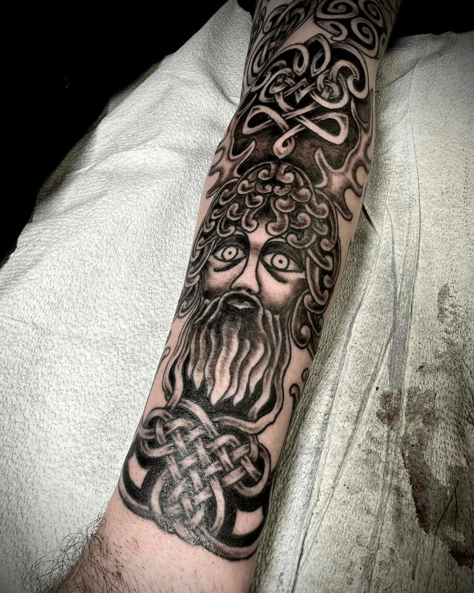 Black and grey mythology sleeve with god and ruins on the lower arm.