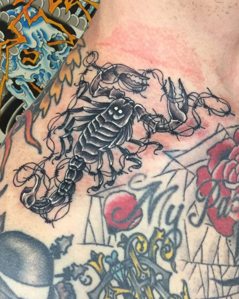 Black and grey  fine-line scorpion tattoo-on the top of shoulder collarbone area.