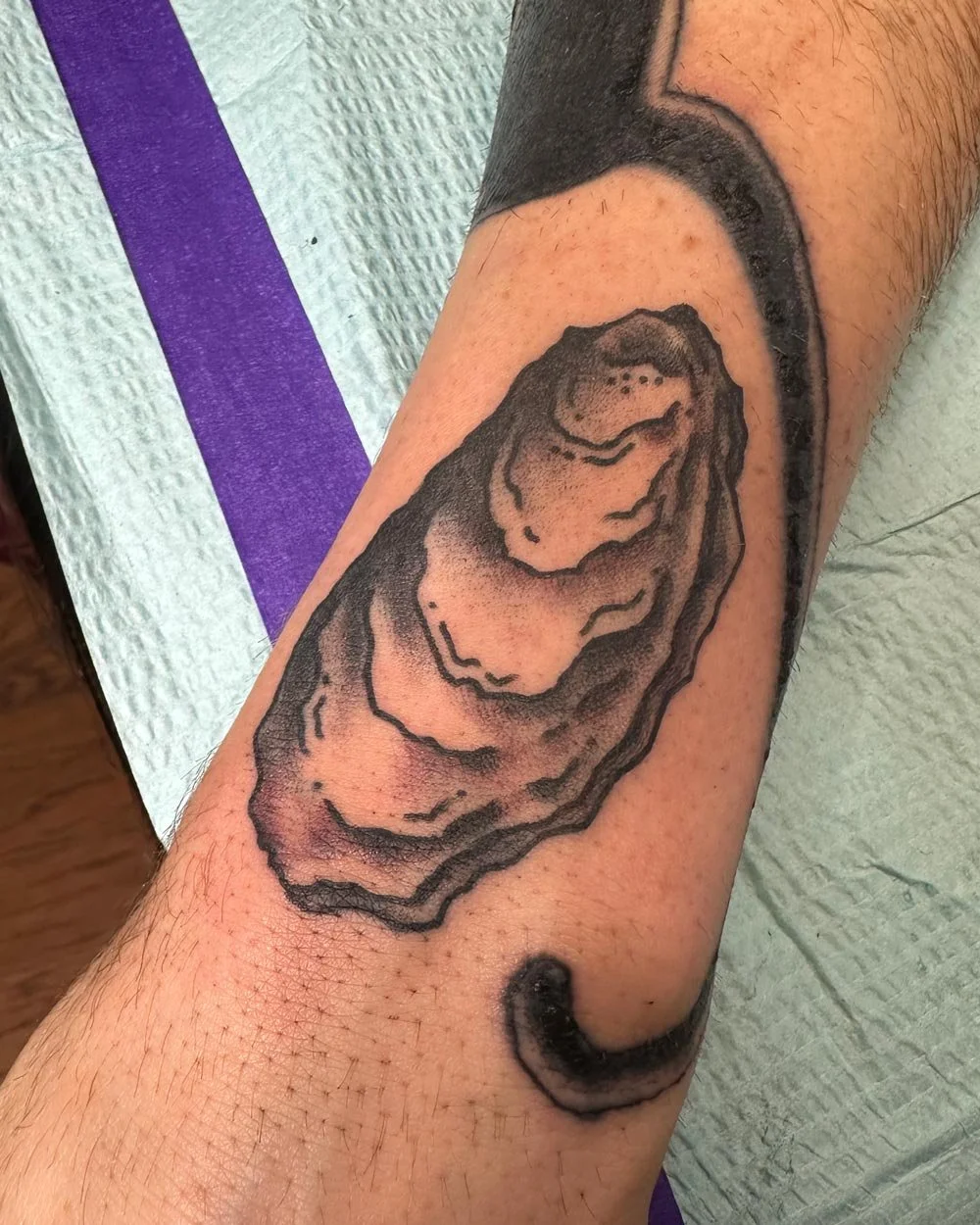 Forearm-illustrative-realistic-tattoo-of-an-oyster-in-black-and-grey.jpg
