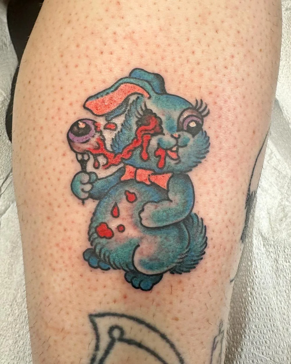 Matching tattoos of zombie bunnies with eyeballs on forks.