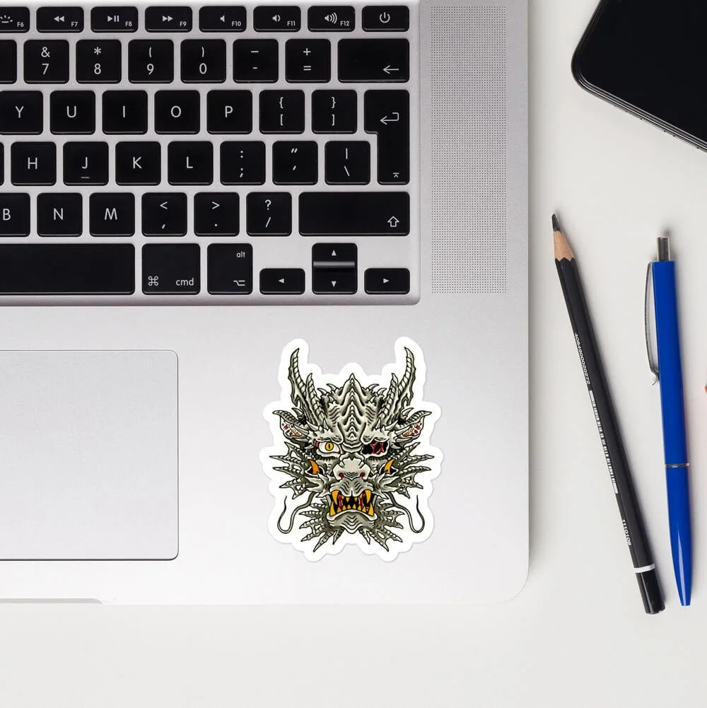 3x3" biomechanical dragon head kiss-cut sticker on a computer.