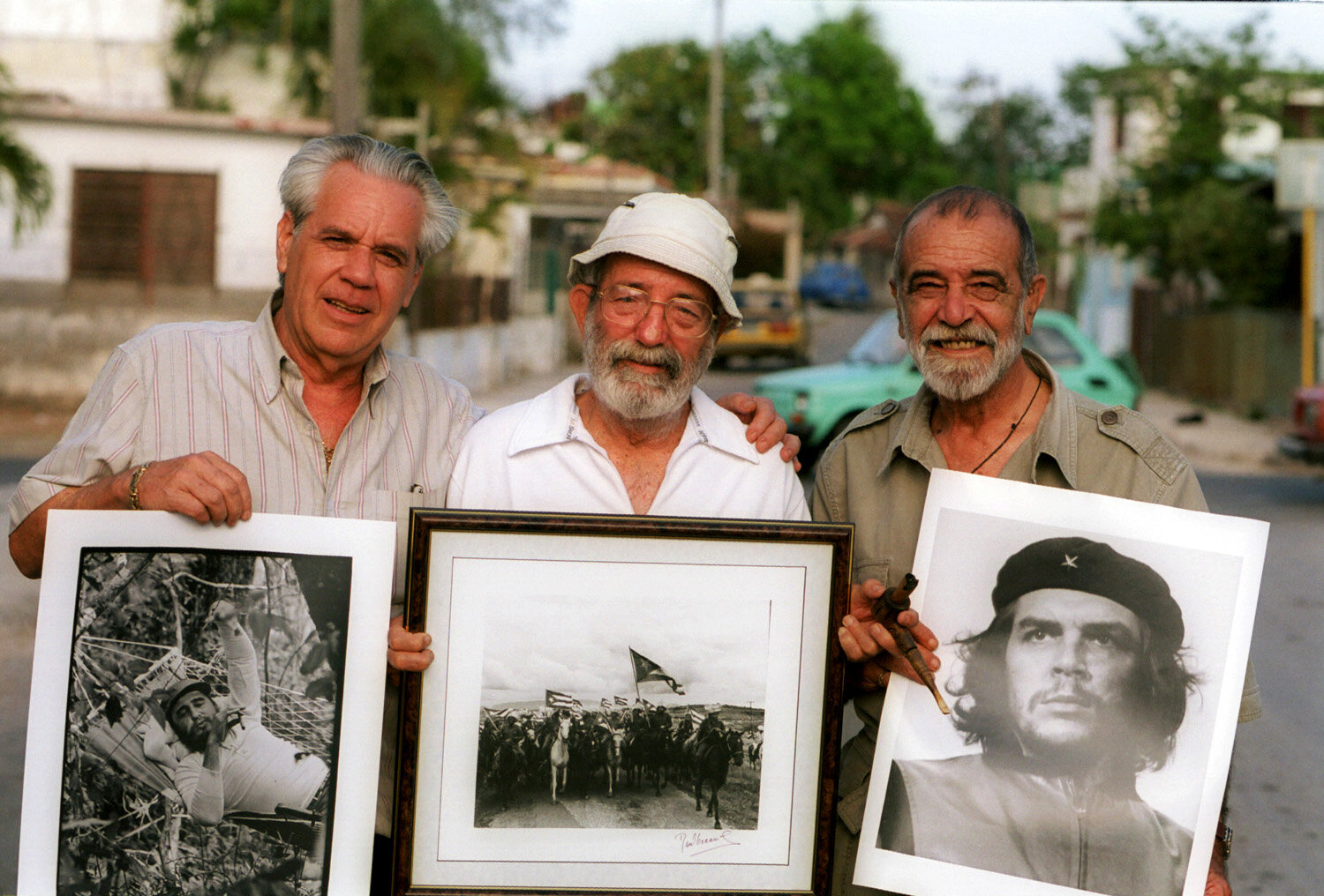  Cuban photographers Roberto Salas, Raul Corrales and Alberto Korda posing with three of their most known pictures, Fidel Castro in a hammock, the cavalry of the revolutionary army, and Che Guevara. 