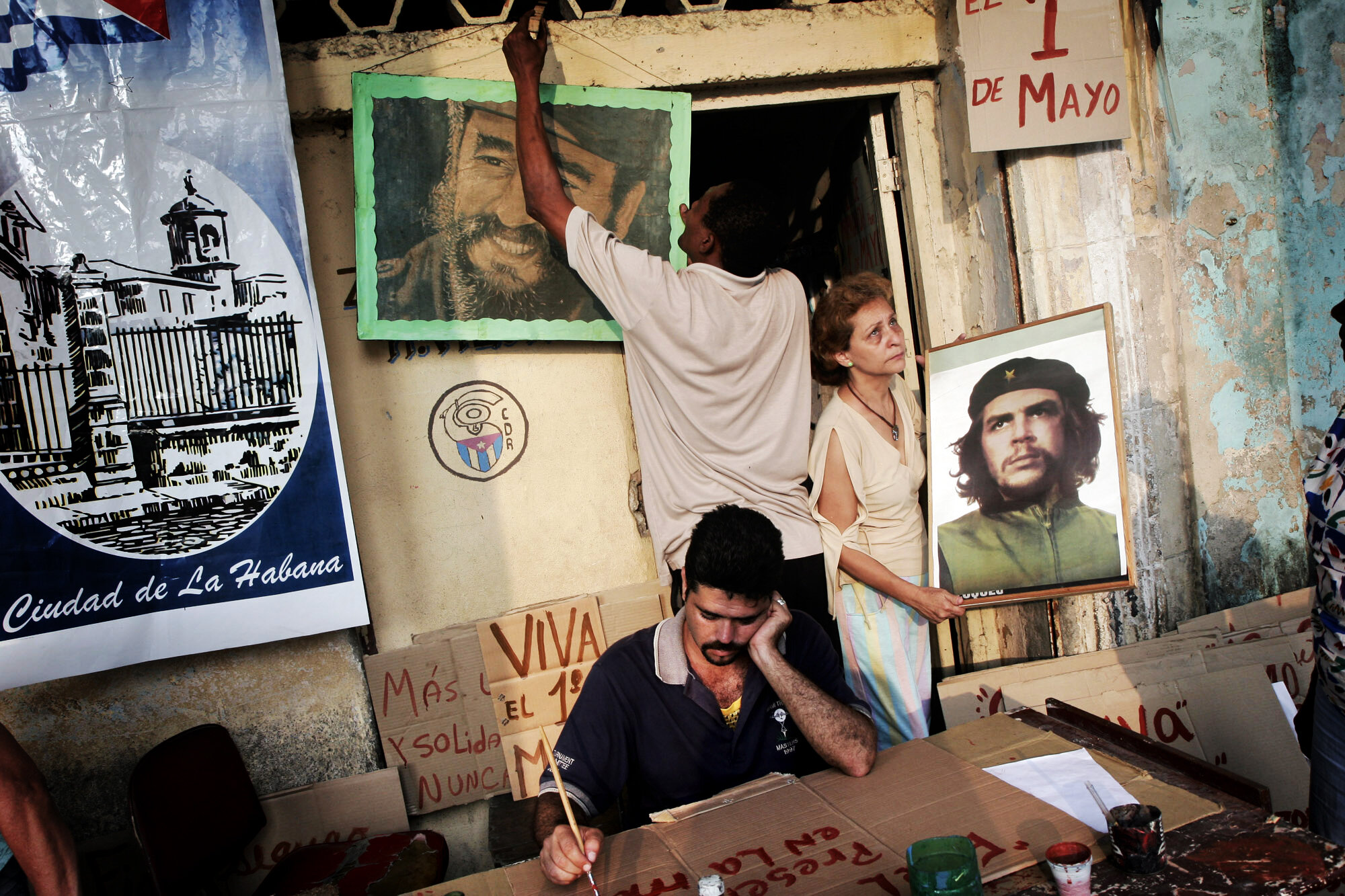  Pictures of Fidel Castro and Che Guevara are being hung up. Members of a CDR paint political slogans and propaganda for the May Day march, 2007.                       