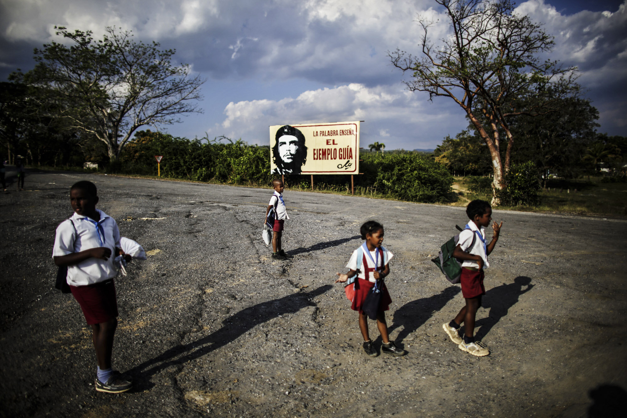  Cuban pioneers pass by a billboard with the image of Che Guevara on their way back home after school, on the road to Vinales, Pinar del Rio, 2014. 