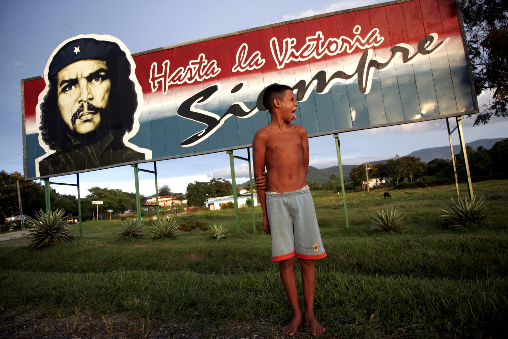  A cuban boy jokes with a friend as he stands under an image of late guerilla fighter Che Guevara in Biran, Fidel Casro's birthplace. Words read the most famous sentence written by Che Guevara: Hasta la Victoria Siempre (Until Victory, forever). 2007