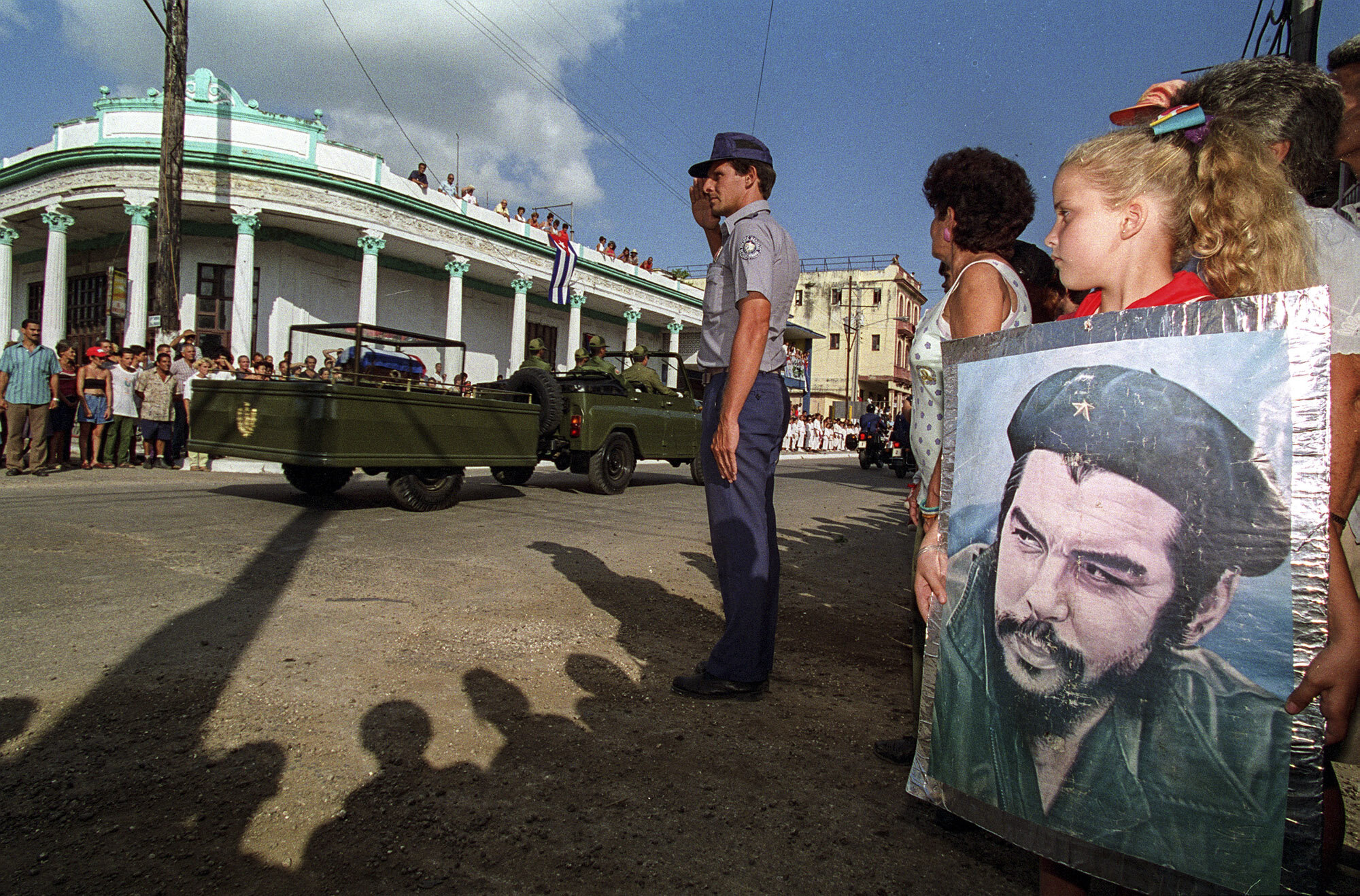  A young Cuban pioneer holds an image of Che as the caravan with his remains passes through a village on its way to Santa Clara. 