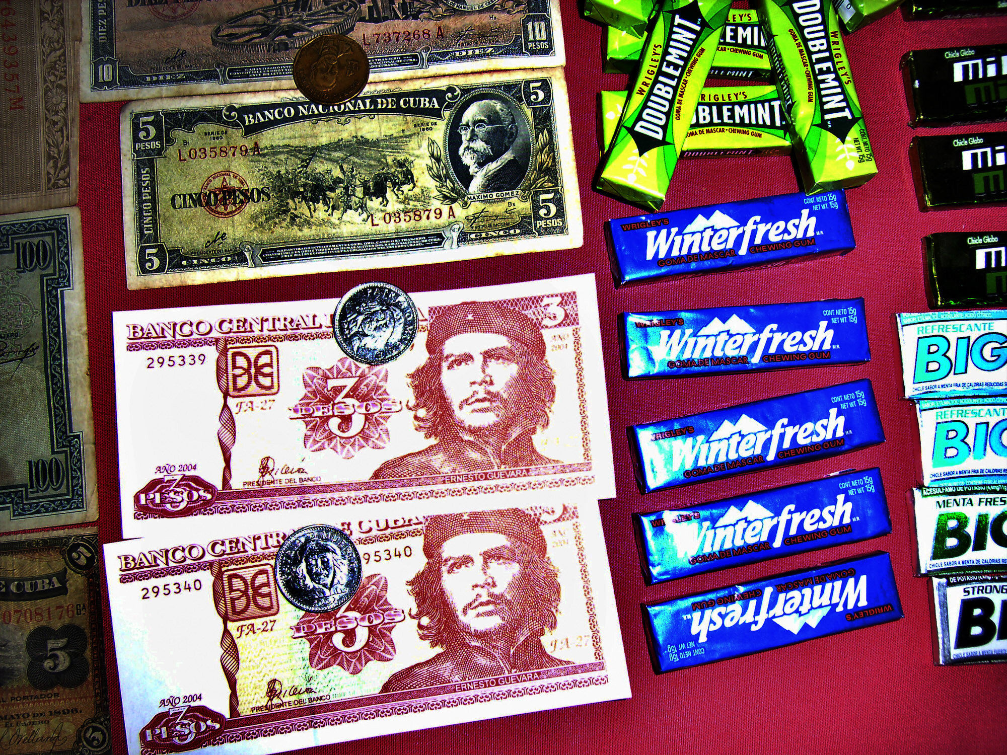  Che Guevar's image on the 3 Peso banknotes and coins of the Cuban Peso, next to chewing gum for sale in a restaurant. 