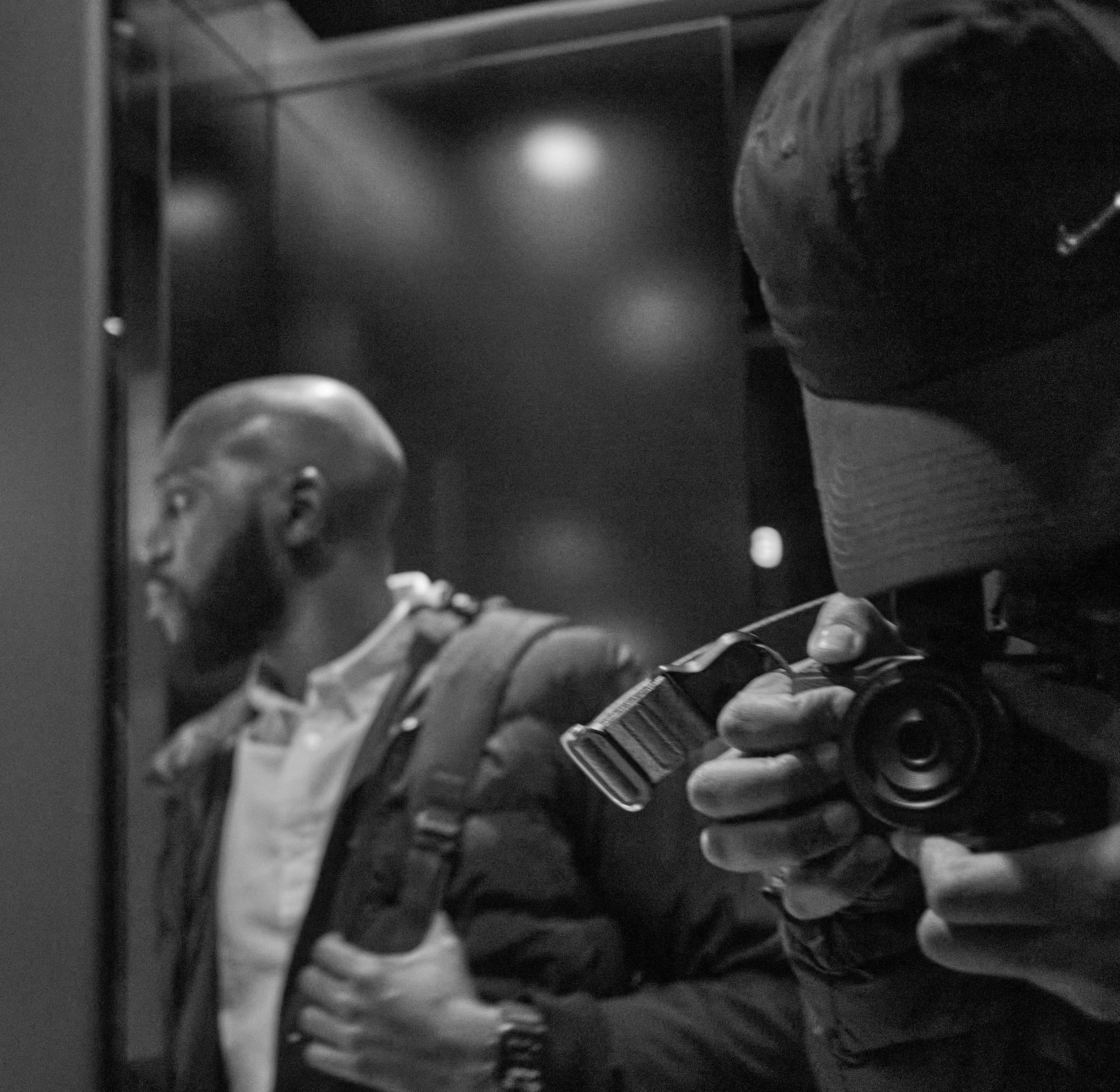 Me and my friend Larry in a dark London elevator. I'm off to the right with my Canon M3, staring down the viewfinder to capture a mirror shot of Larry heading out the elevator on the opposite side of me.