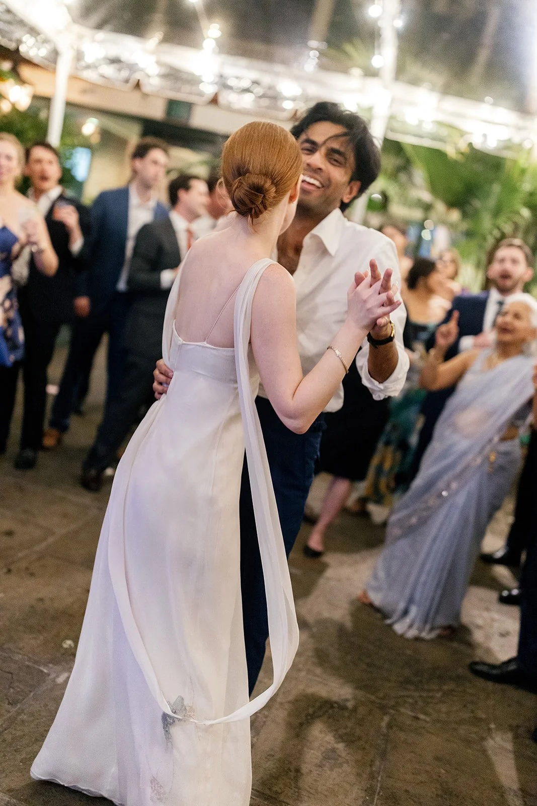 A couple dancing at their wedding reception at Brennan's New Orleans with guests in the background.
