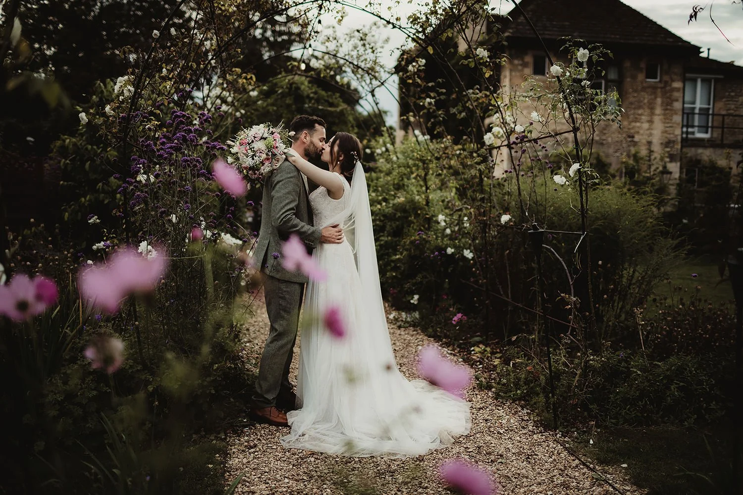Bride and groom kissing among flowers