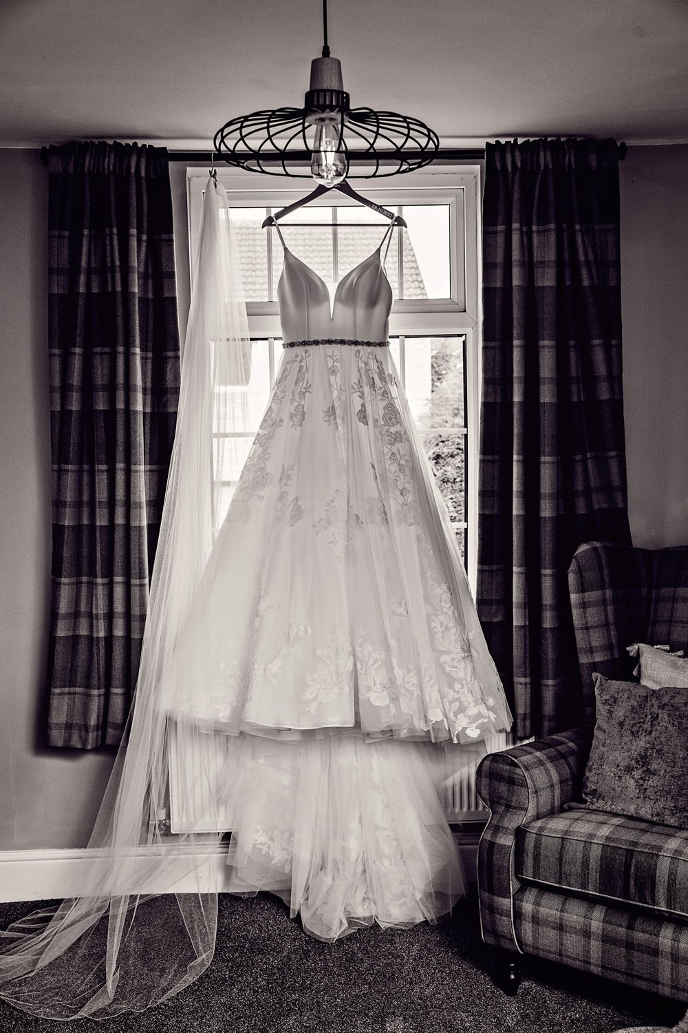 Wedding dress hanging by window